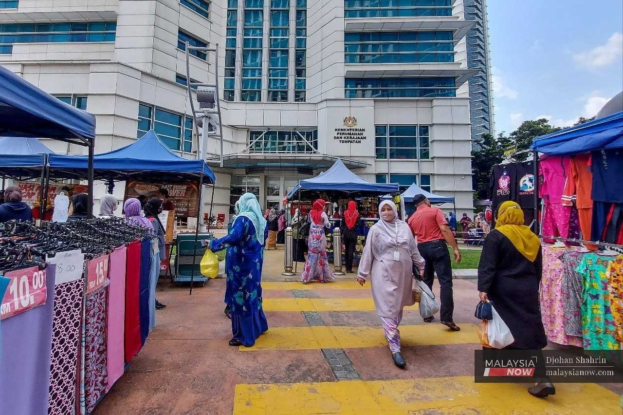 Civil servants mill about outside a ministry building in the administrative capital of Putrajaya. 
