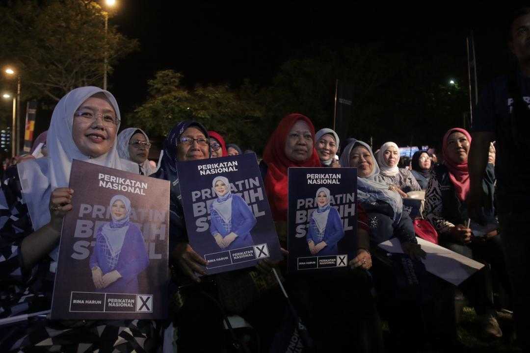 Penyokong memegang poster Ketua Wanita PN Rina Harun.