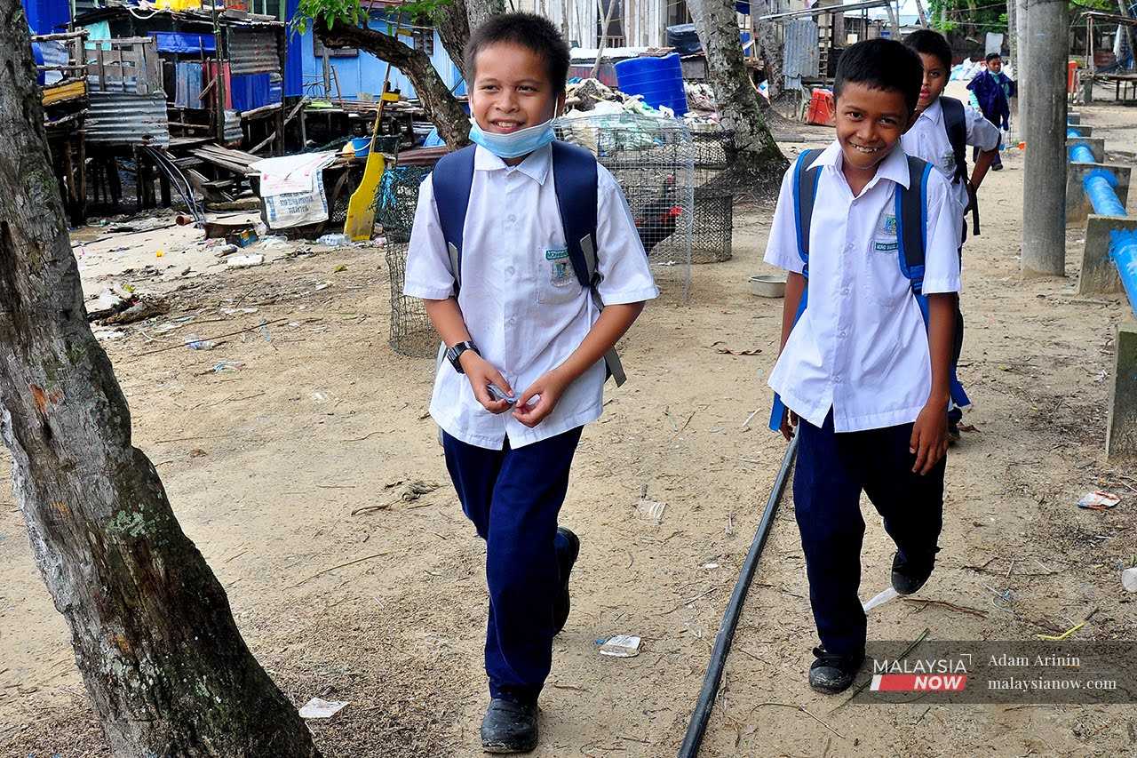 Two schoolboys in Sabah on their way home. Critics say that the RM8.4 million spent on flag pins could have been used to solve other pressing problems in schools, especially in the interiors.