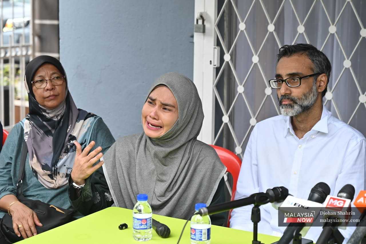 Resident and activist Rafidah Ibrahim, who also lost her home yesterday, sheds tears during the press conference.