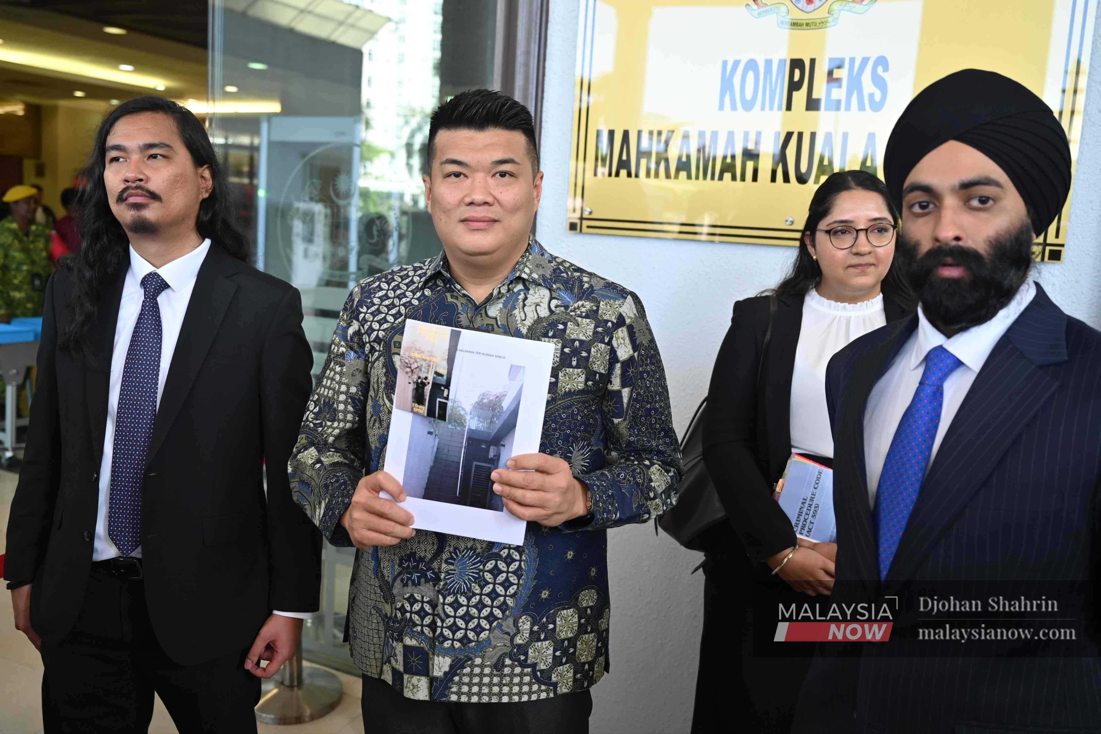 Albert Tei, flanked by lawyers Zaid Malek (left) and Mahajoth Singh, shows the image sent to him from an unknown foreign mobile number.