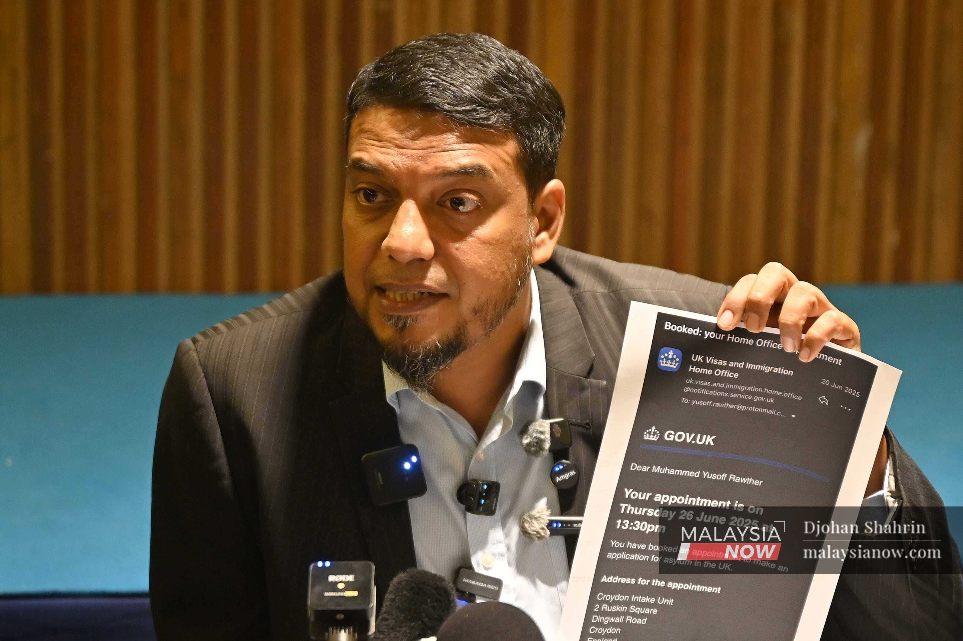 Peguam Rafique Rashid menunjukkan dokumen permohonan Yusoff Rawther untuk mendapatkan suakan daripada kerajaan United Kingdom.
